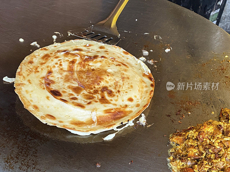 近距离拍摄Frankie (Mumbai Burrito)街头小吃，在Tawa(大而扁平的金属烹饪锅)，paratha(大饼)，paneer填充煎炸，高架视图，前景聚焦